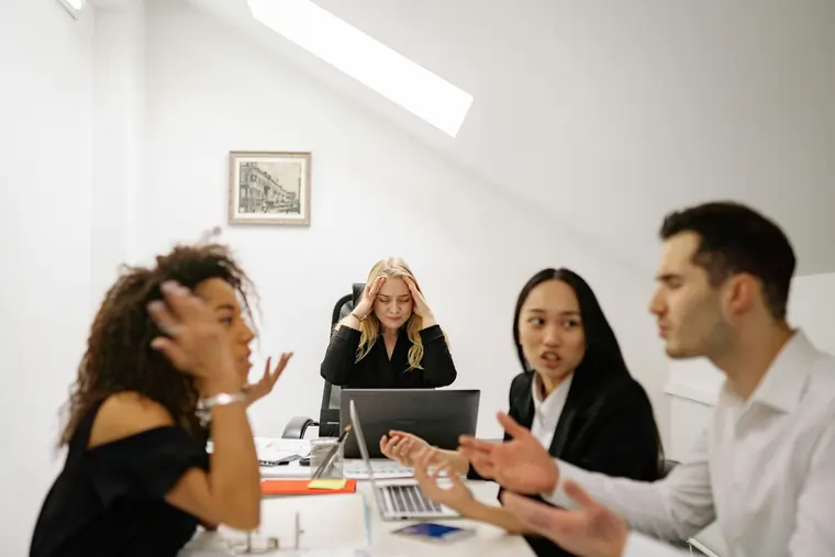 Gruppo di tre collaboratori litigano in azienda, il quarto si porta le mani alla testa. Ma come si è arrivati a questo punto? | MentiPratiche